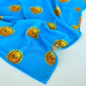 High contrast smiling sun print on muslin swaddle. 