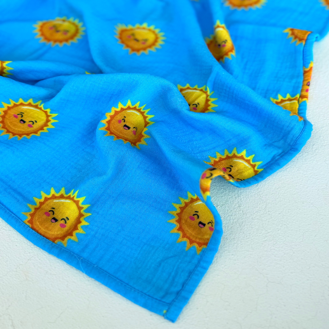 High contrast smiling sun print on muslin swaddle. 